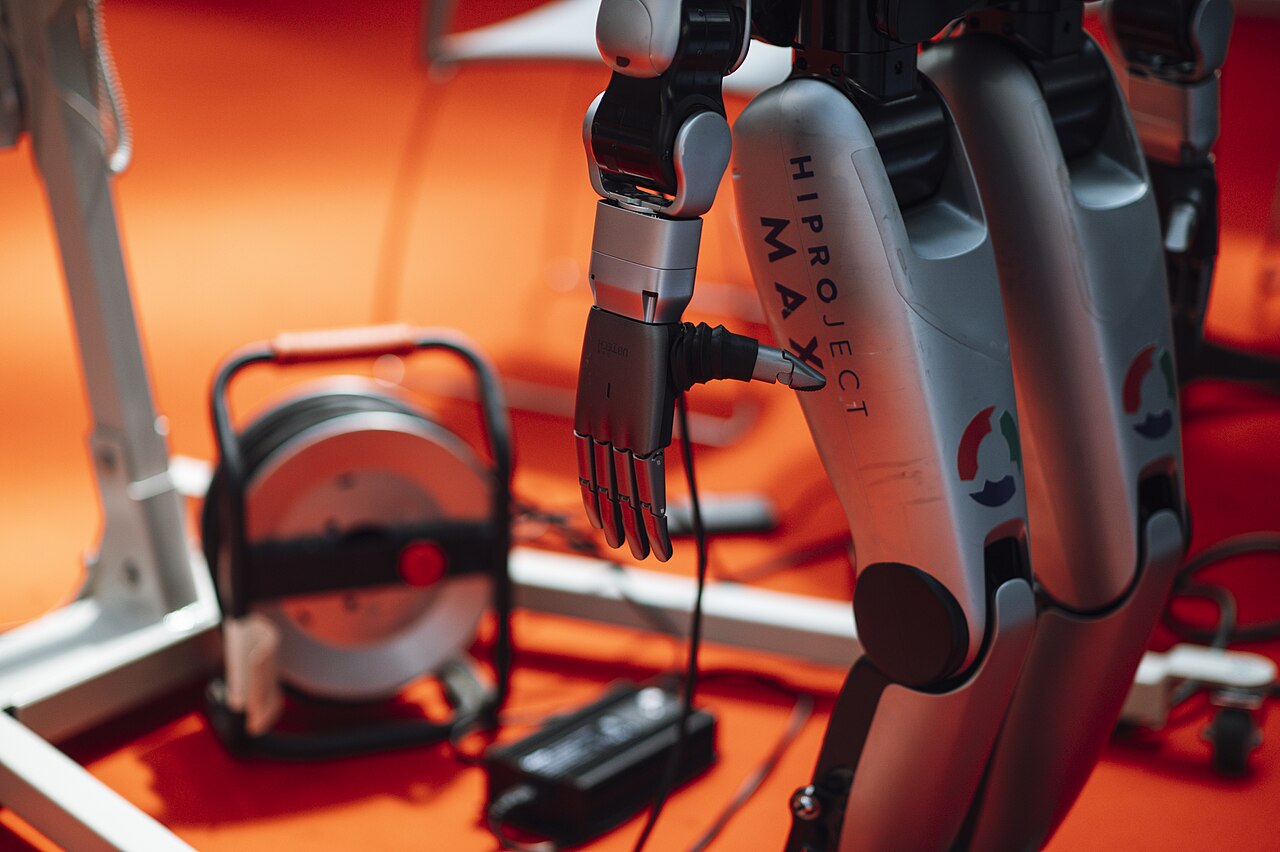 มือหุ่นยนต์กำลังหยิบเครื่องมือในงานแสดงเทคโนโลยี
